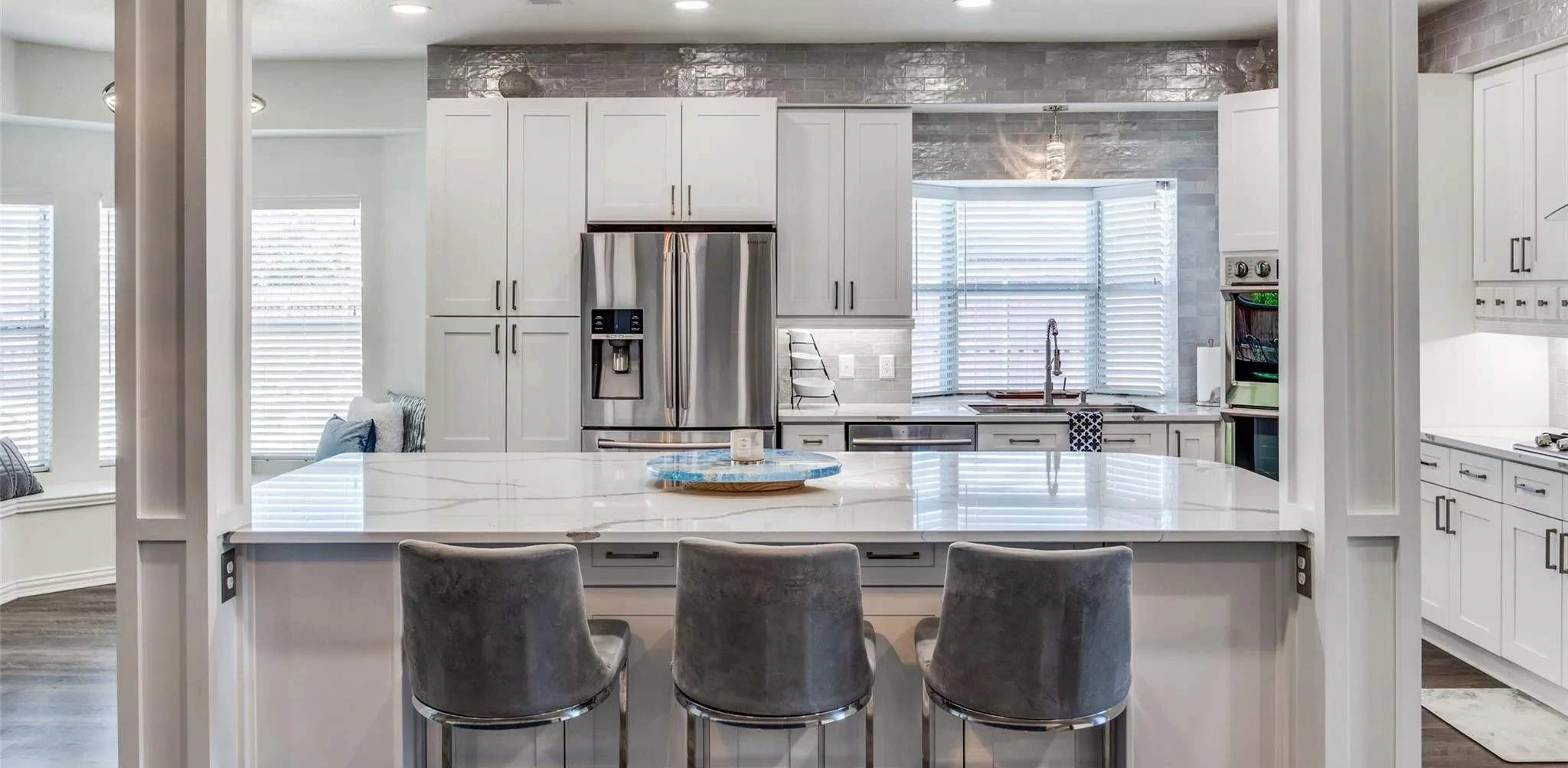 Custom kitchen remodel with white cabinetry, quartz countertops, and professional appliances